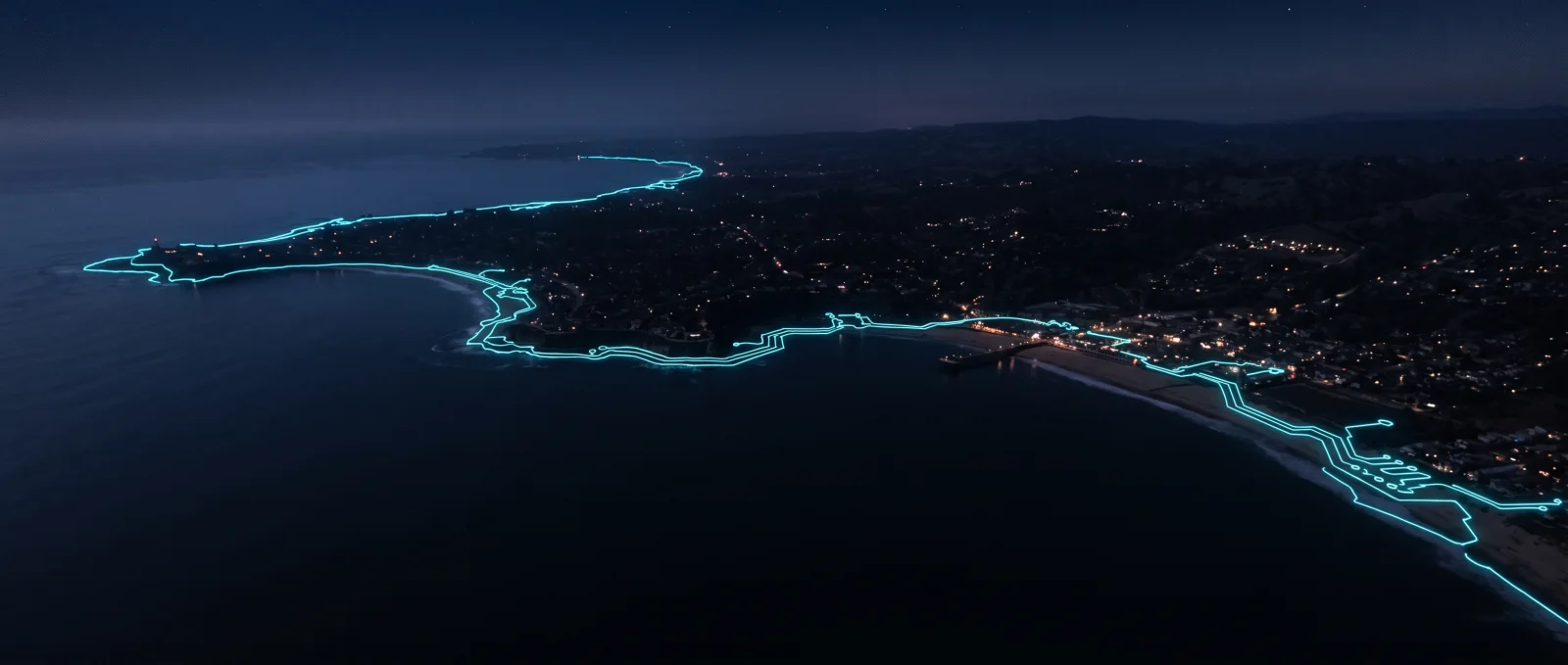 The Santa Cruz coastline at night, traced in light